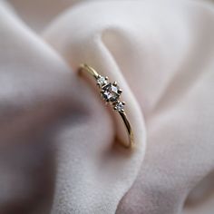 a diamond ring sitting on top of a white cloth