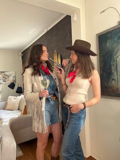 two women in cowboy outfits standing next to each other