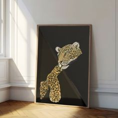 a framed photograph of a cheetah on a wall in a room with wood flooring