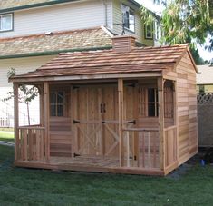 a wooden shed sitting on top of a lush green field