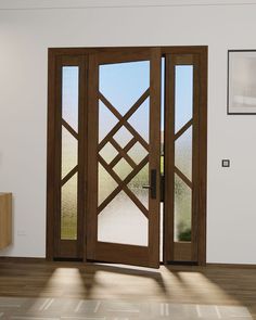 an open wooden door in a white room with wood flooring and potted plant