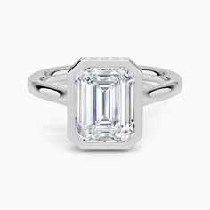 an emerald cut diamond ring on a white background