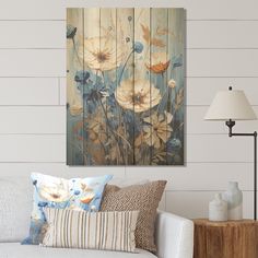 a living room scene with focus on the couch and wall art that has flowers painted on it