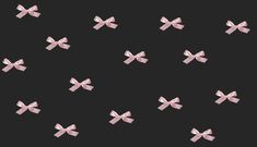 many pink bows are flying in the air on a black background with space for text