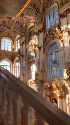 an ornate building with gold and white decorations on the walls, stairs and balconies