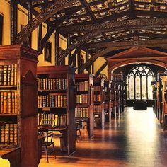 an old library filled with lots of wooden bookshelves and tall arched doorways