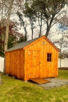 a small wooden shed sitting in the grass