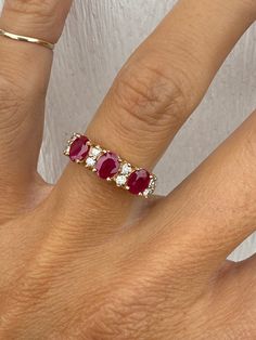 There are 3 genuine oval rubies measuring 5mm x 4mm for approx 1.20ctw. There are 8 round diamonds of approximately .12ctw M/SI1-I1 The ring weighs 3.2g and measures 5mm at its widest point. The shank tapers to 2mm at the very back. It is stamped for 14k yellow gold. Ring size is 6 and sizable.  I can size it for an additional charge. Let me know if you need a quote. Yellow Gold Anniversary Band, Gold Anniversary Bands, Round Diamond Ring, Gold Anniversary, Anniversary Bands, Rings Statement, Round Diamond, Gold Ring, Round Diamonds