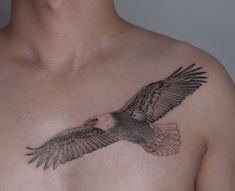 a man with a bald eagle tattoo on his chest