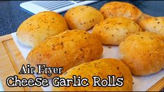 some bread rolls on a cutting board with the words air fryer cheese garlic rolls