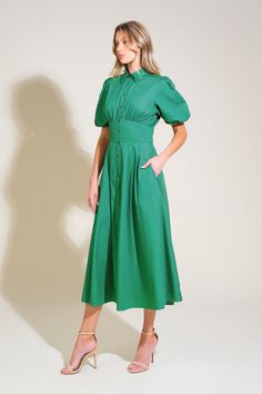 A solid woven midi dress featuring shirt collar, button down, short puff sleeve, waist yoke and full skirt Details: Self : 100% Cotton Size & Fit - Model is 5`8" And Wearing Size Small- Measurements Taken From Size Small- Approx. Length: 50" Chic Green A-line Shirt Dress, Puff Sleeve Shirt Dress With Buttons For Work, Casual Midi Length Puff Sleeve Dress For Work, Green Collared Shirt Dress For Work, Classic Puff Sleeve Summer Dress, Formal Knee-length Puff Sleeve Dress With Button Closure, Green Buttoned Midi Dress For Casual Wear, Chic Midi-length Puff Sleeve Dress With Button Closure, Green Fitted Cotton Puff Sleeve Dress