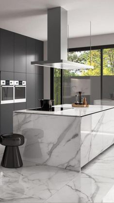 a modern kitchen with marble counter tops and black cabinets, along with an island in the middle