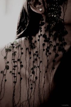 the back of a woman's body covered in vines