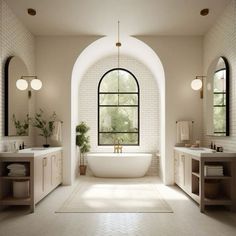 a large white bath tub sitting under a window in a bathroom next to two sinks