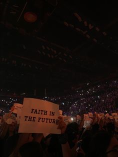 a group of people holding up signs in front of an audience