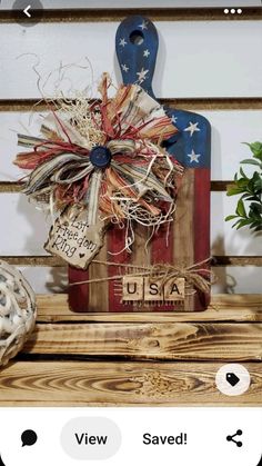 a wooden cutting board decorated with an american flag bow and some burlwood tags