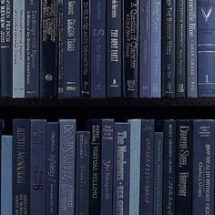 several books are stacked on top of each other in a bookcase, with one being read