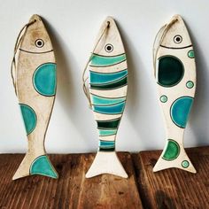 three wooden fish are sitting next to each other