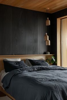 a large bed sitting next to a window in a room with wooden floors and walls