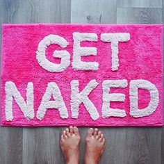 someone is standing on the floor with their feet in front of a pink rug that says get naked