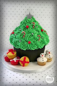 a cupcake decorated with green frosting and christmas decorations