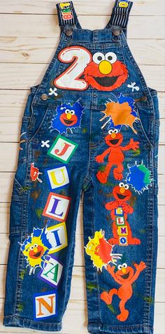 the sesame street overalls are decorated with cartoon characters and numbers on denim dungks