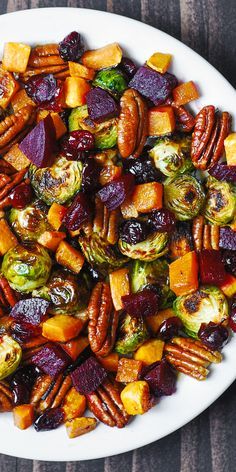 a white plate topped with brussel sprouts and sweet potatoes