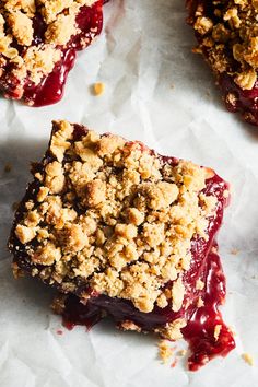 two pieces of pie with crumb toppings on top of white paper and one piece cut in half