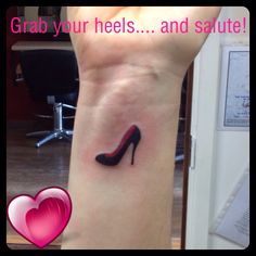 a woman's foot with a high heel tattoo on her left ankle and the words grab your heels and salute