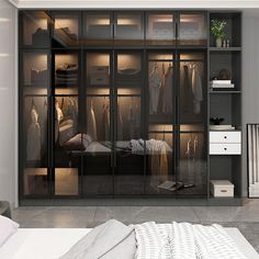 a walk in closet with glass doors and clothes hanging on the walls, along with a bed