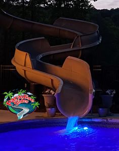 a water slide in the middle of a pool with blue lights on it's sides