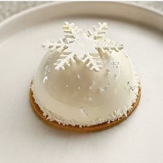 a white plate topped with a cookie covered in icing and snowflakes on top of it