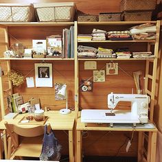 a sewing machine sitting on top of a wooden table next to a shelf filled with books