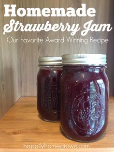 homemade strawberry jam in two mason jars on a wooden table with text overlay reading homemade strawberry jam our favorite award winning recipe