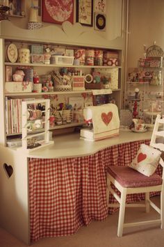 a room filled with lots of furniture and accessories on shelves next to a table covered in red and white checkered cloths