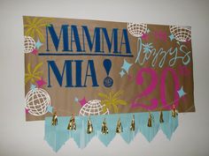 a sign that says mamma mia hangs on the wall next to other signs with tassels hanging from them