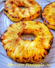 grilled pineapples on a white plate with the words air fryer pineapple