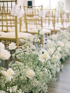 white flowers and baby's breath are lined up along the aisle