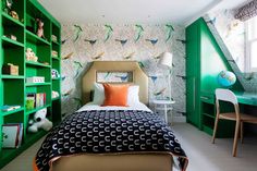 a bed room with a neatly made bed and green bookshelves