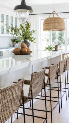 a kitchen with white counter tops and wicker chairs