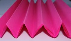 pink folded paper sitting on top of a table