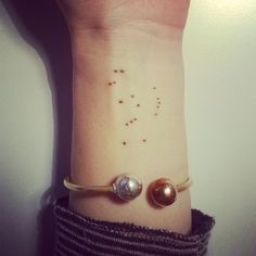 a wrist tattoo with two planets on it