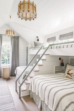 a bedroom with bunk beds and stairs leading up to the second floor, in white painted wood