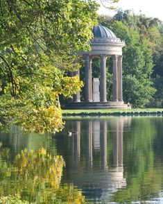 a gazebo sitting on top of a lake surrounded by trees