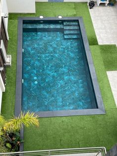 an aerial view of a swimming pool with artificial grass