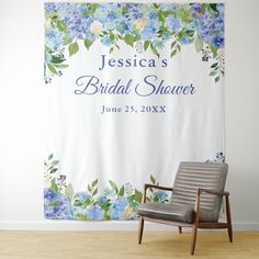 a chair sitting in front of a white wall with blue flowers on it and the name jenny