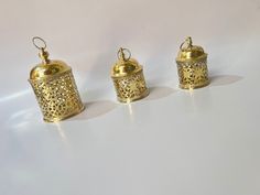 three small gold canisters sitting next to each other on a white table top