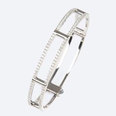 An elegant and modern bangle bracelet with a dusting of sparkling white diamonds along its lateral bars. 18K white gold locking cage bangle bracelet with white diamonds on lateral bars (1.2 tcw) 7.0” internal circumference 0.63” wide Luxury Diamond White Diamond Bangle, Modern Bangle, Contemporary Jewelry, White Diamonds, White Gold Diamonds, Bangle Bracelet, Diamond White, Gold Diamond, Bangle Bracelets