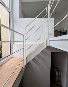 a white stair case next to a window