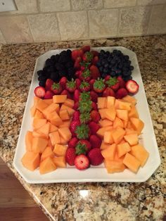 a platter filled with cut up fruit on top of a counter